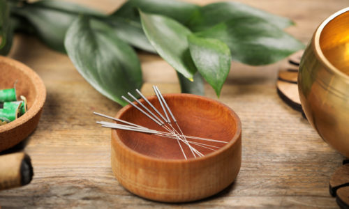 Bowl with acupuncture needles on wooden table Bowl with acupuncture needles on wooden table